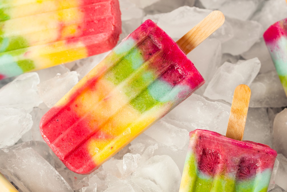 Top view of colorful popsicles on ice
